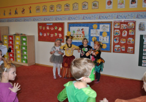Czworo dzieci tańczy przed innymi dziećmi.